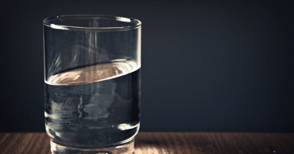 A glass of water on a wooden table _ Self care activities for adults