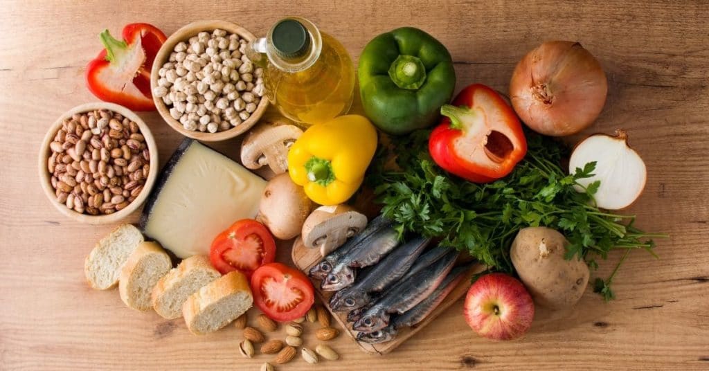 Lots of foods in a Mediterranean Diet, like chickpeas, nuts, olive oil, sardines, and fresh vegetables, which is a nutrition protocol prescribed for Lupus