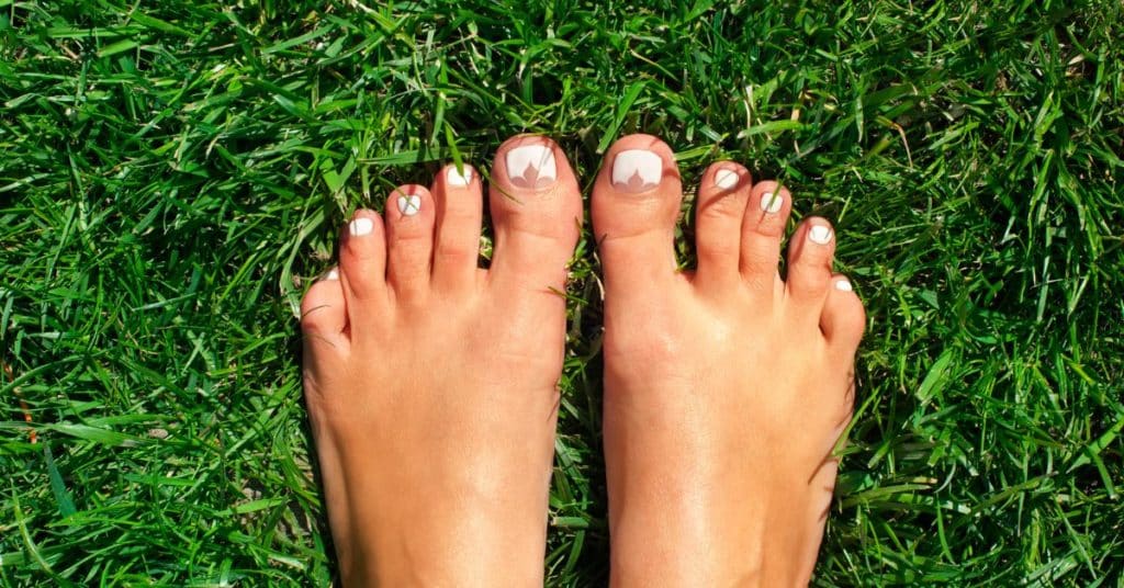 Woman's bare feet in grass, Health Benefits of Grounding