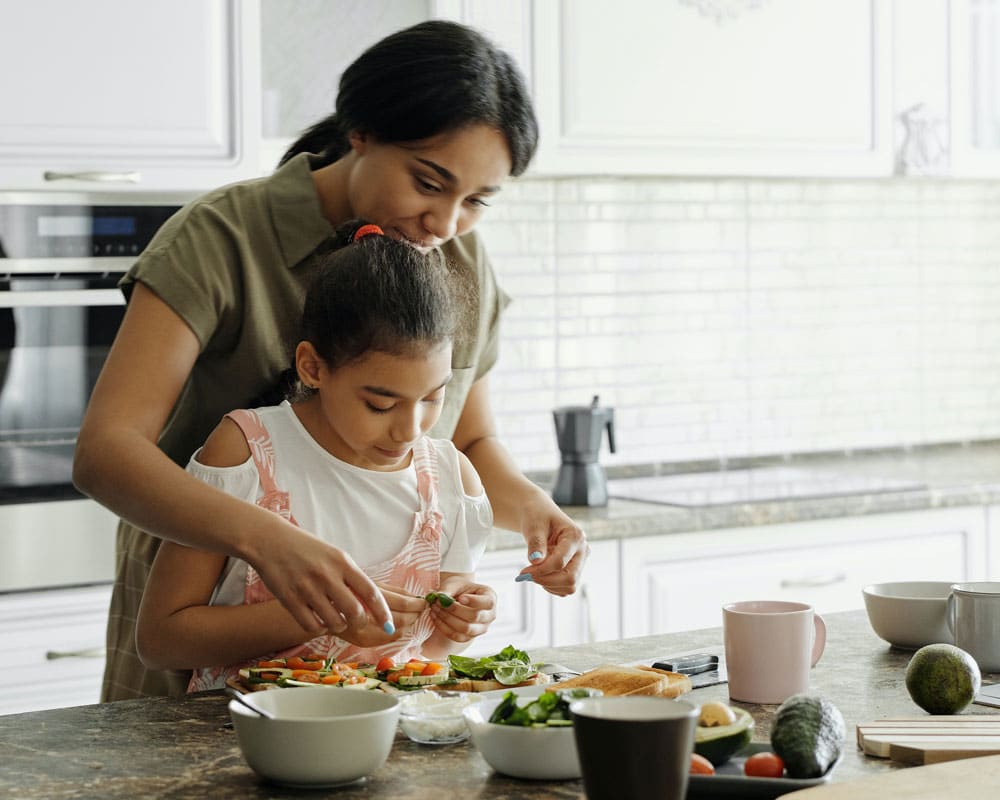 A mother and child cook a healthy snack together in the kitchen, pediatric nutrition