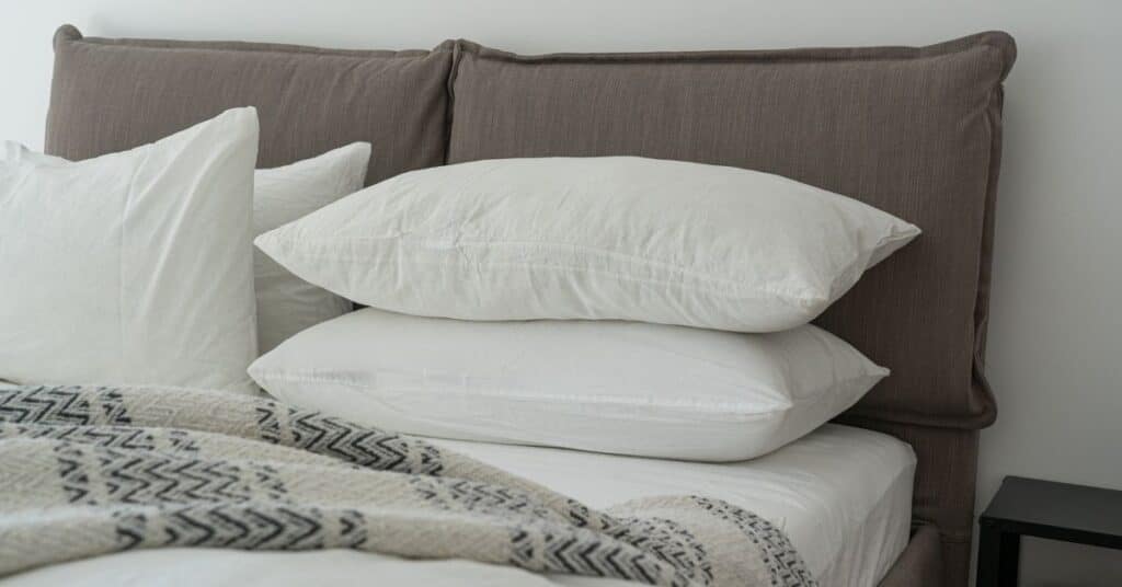 Pillows and blankets nicely stacked on a bed, indoor pollution examples
