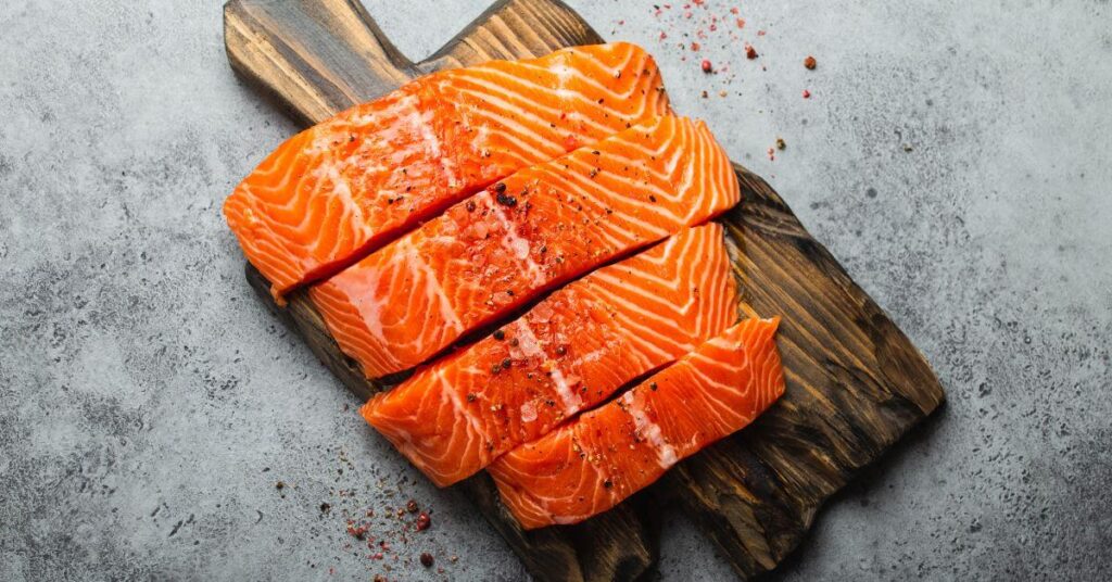 A sliced salmon filet on a wooden cutting board