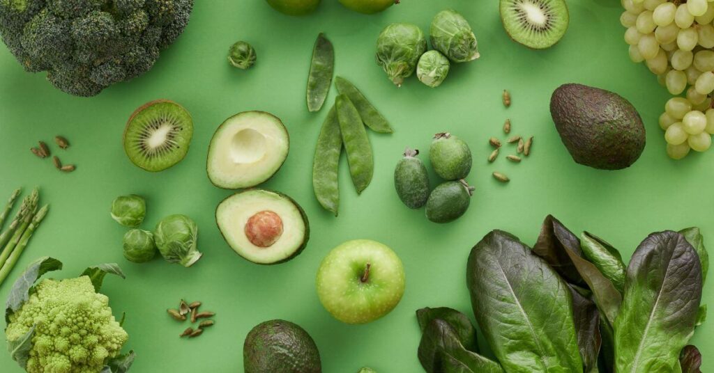 Green foods, including avocado, broccoli, peas, Brussels sprouts and kiwi, are arranged aesthetically, Anti-inflammatory Diet Vs Autoimmune Diet