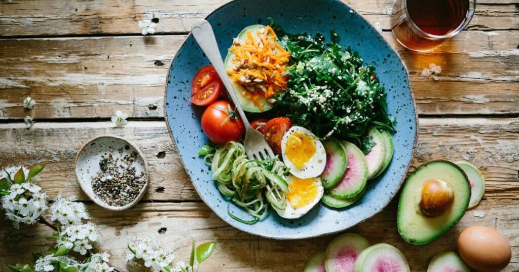 A bowl with a fresh salad on a wooden table