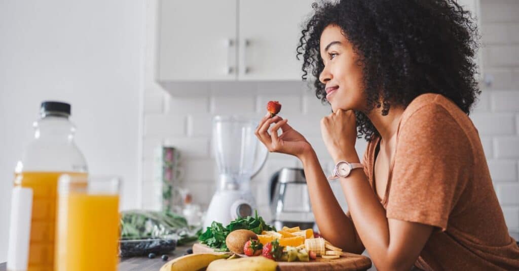 Happy woman eating a strawberry, Natural Ways to Reduce Blood Pressure