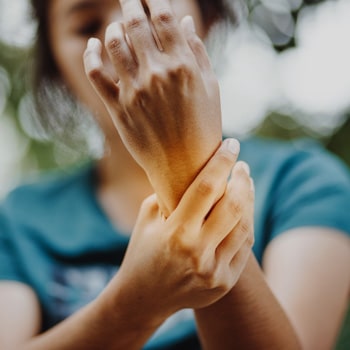 Women with arthritis holds her wrist and hand, autoimmune disease supplement support