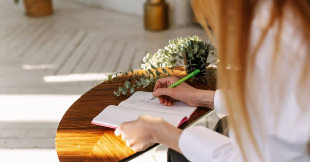 Woman writing in a food journal, restrictive dieting