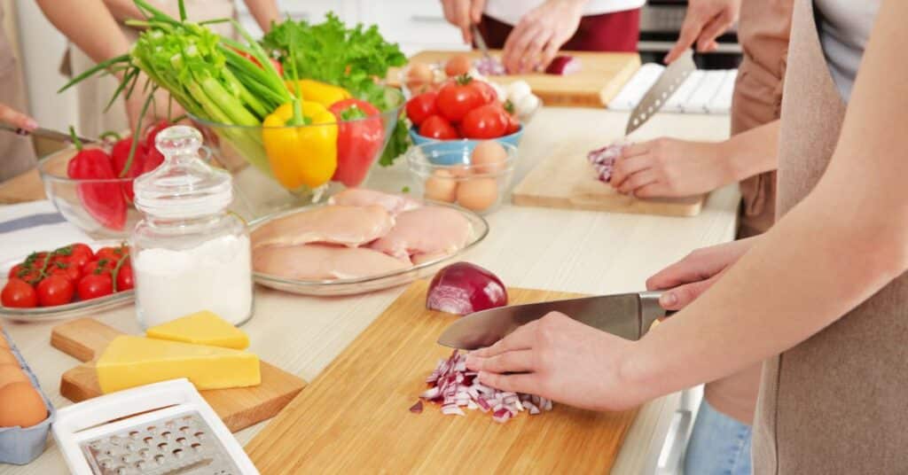 Cooking class at a table where everyone is dicing onions, dietitian vs nutritionist